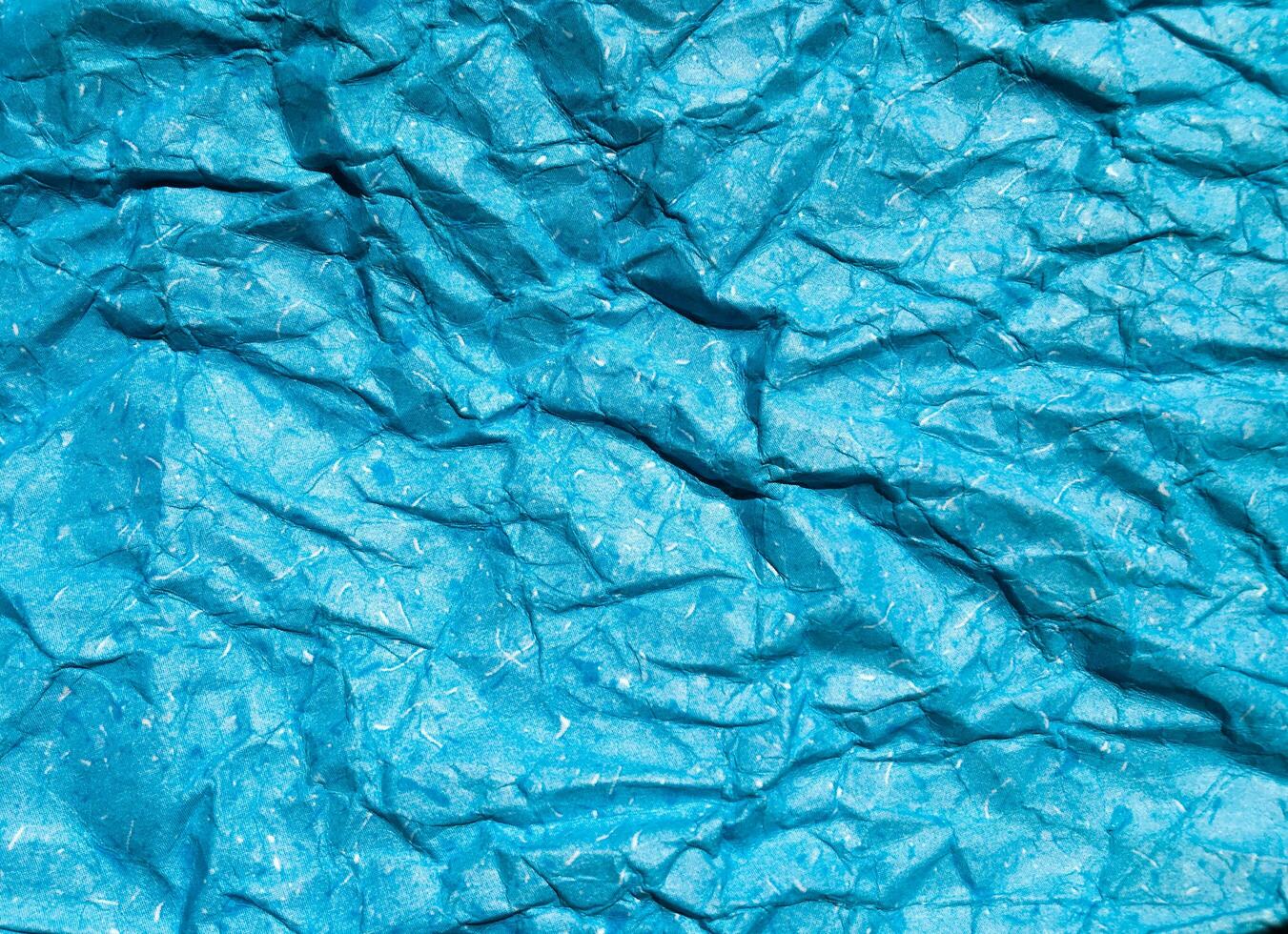 Texture of blue crumpled paper background for design photo