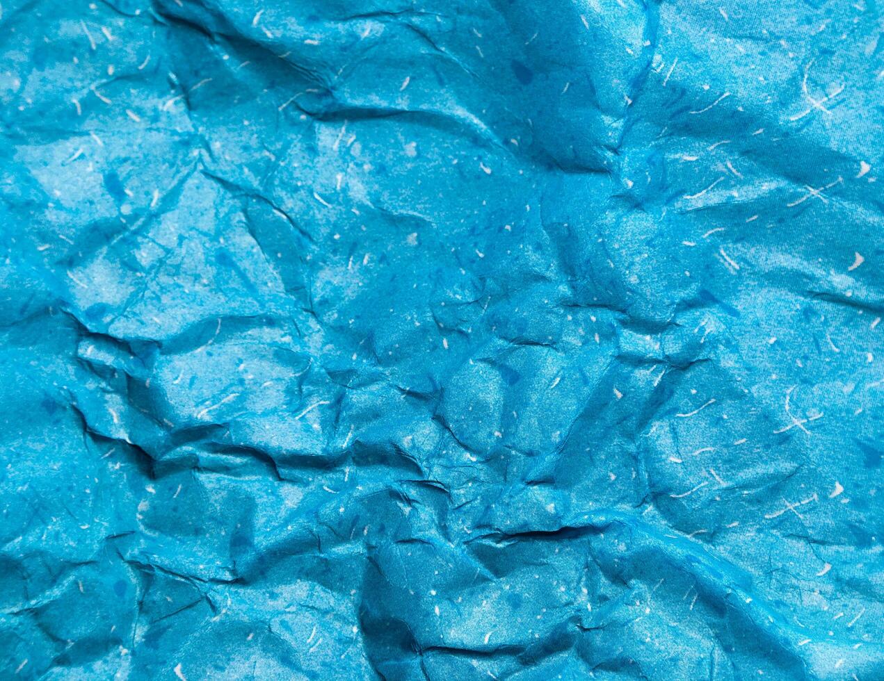 Texture of blue crumpled paper background for design photo