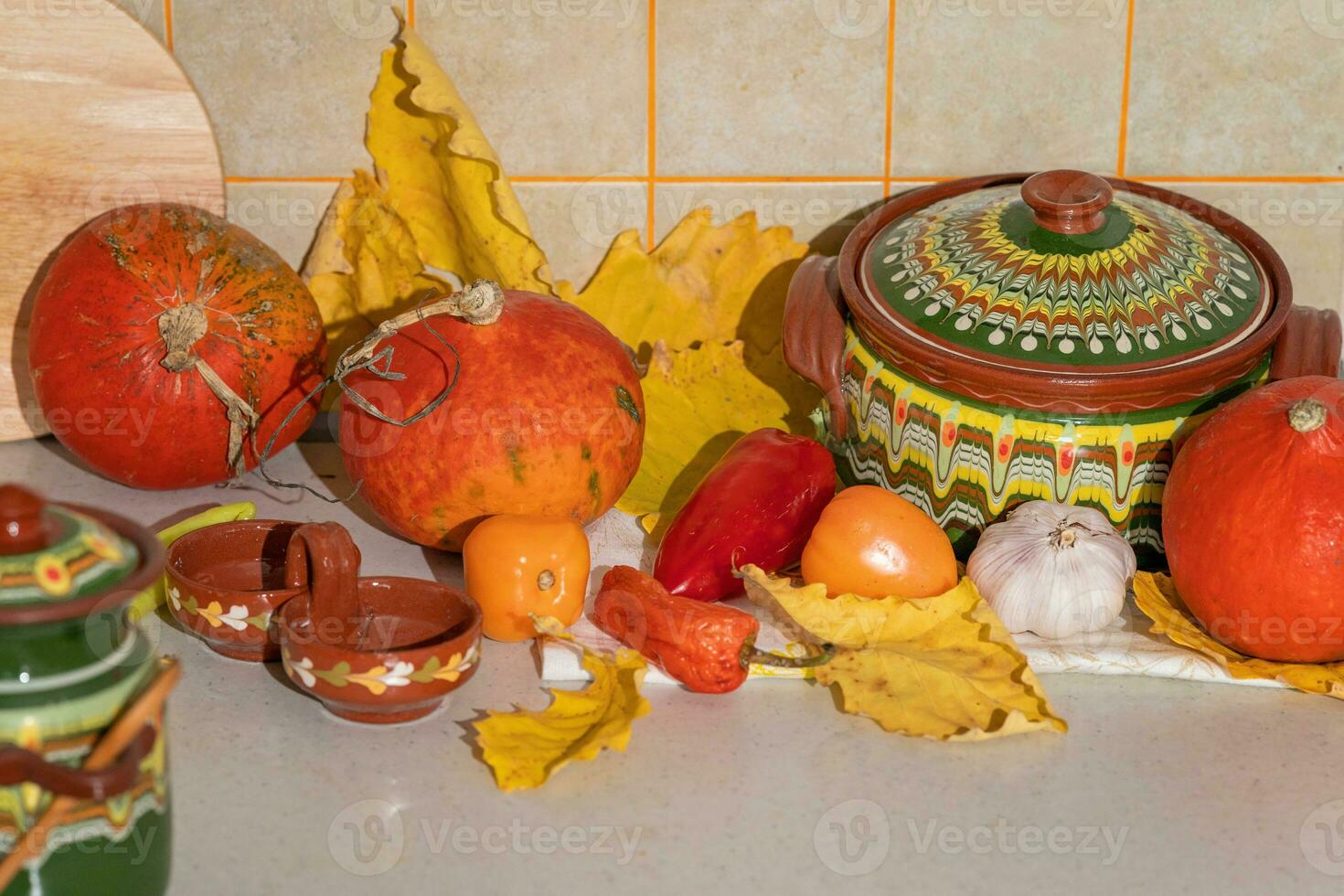 Seasonal harvest of pumpkins and vegetables, ingredients for preparing a dish, advertising and autumn concept - close-up of pumpkins and leaves on the table at home photo