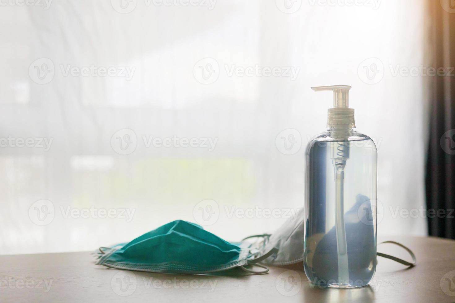 mascarilla médica con gel desinfectante de alcohol lavado a mano en mesa de madera para el concepto de prevención del coronavirus covid-19 foto