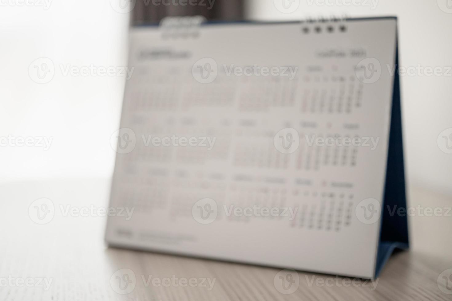 Blur calendar page close up on wood table background business planning appointment meeting concept photo