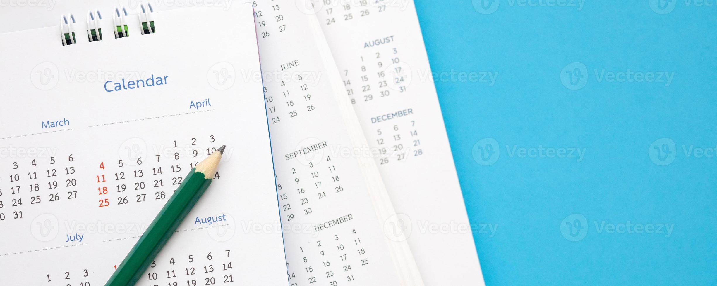 página de calendario con lápiz de cerca sobre fondo azul concepto de reunión de cita de planificación empresarial foto