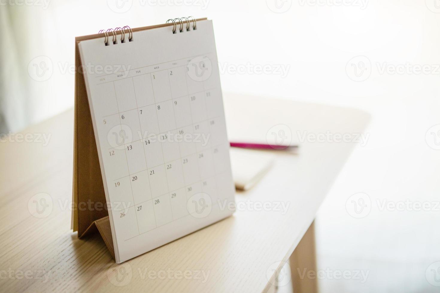 calendar page close up on wood table background with pen and notebook business planning appointment meeting concept photo