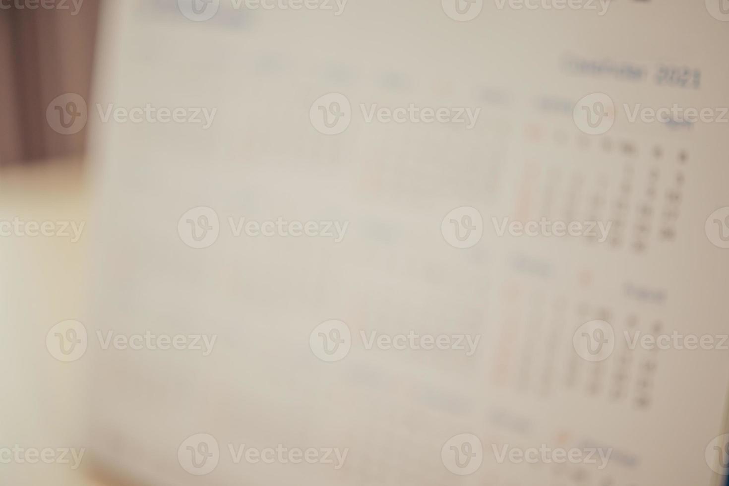 Blur calendar page close up on wood table background business planning appointment meeting concept photo