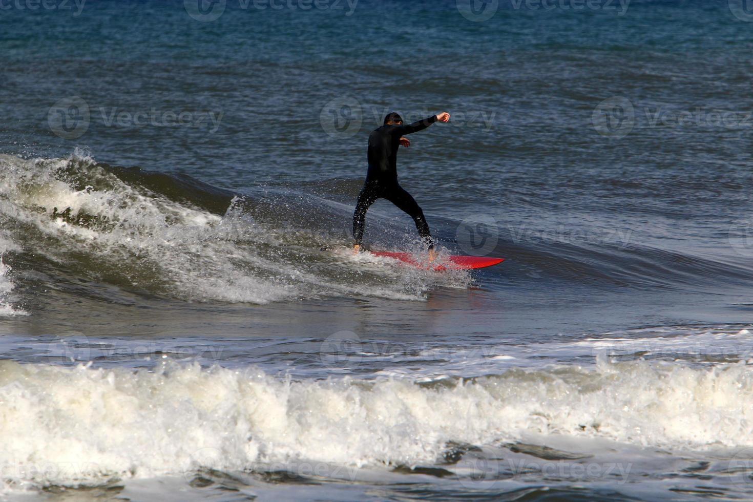Surfing on high waves on the Mediterranean Sea in northern Israel. photo