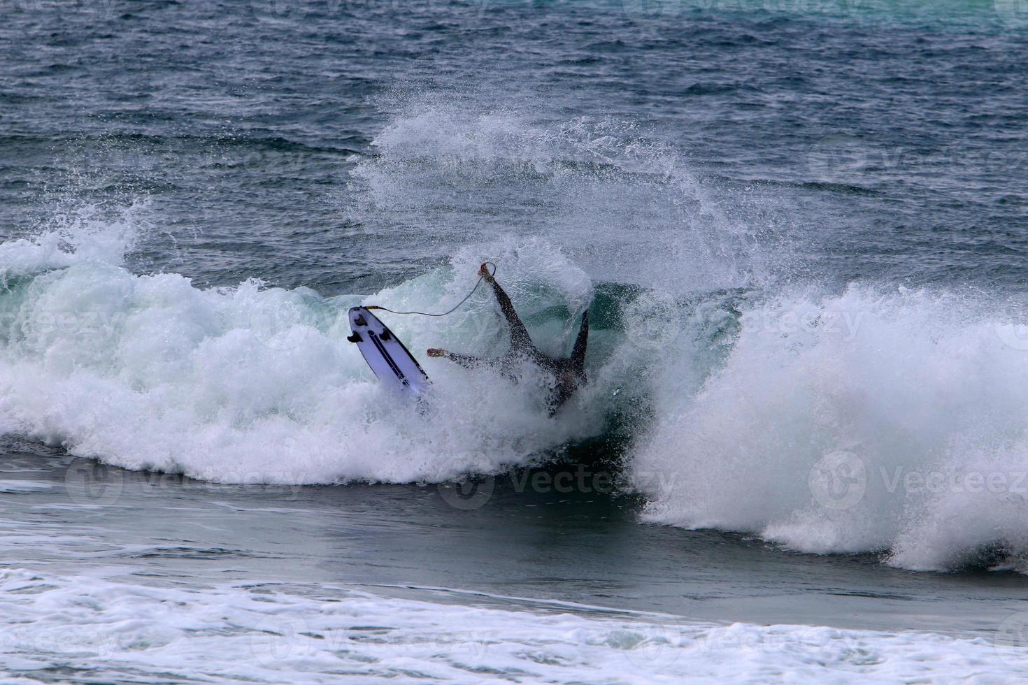 Surfing on high waves on the Mediterranean Sea in northern Israel. photo