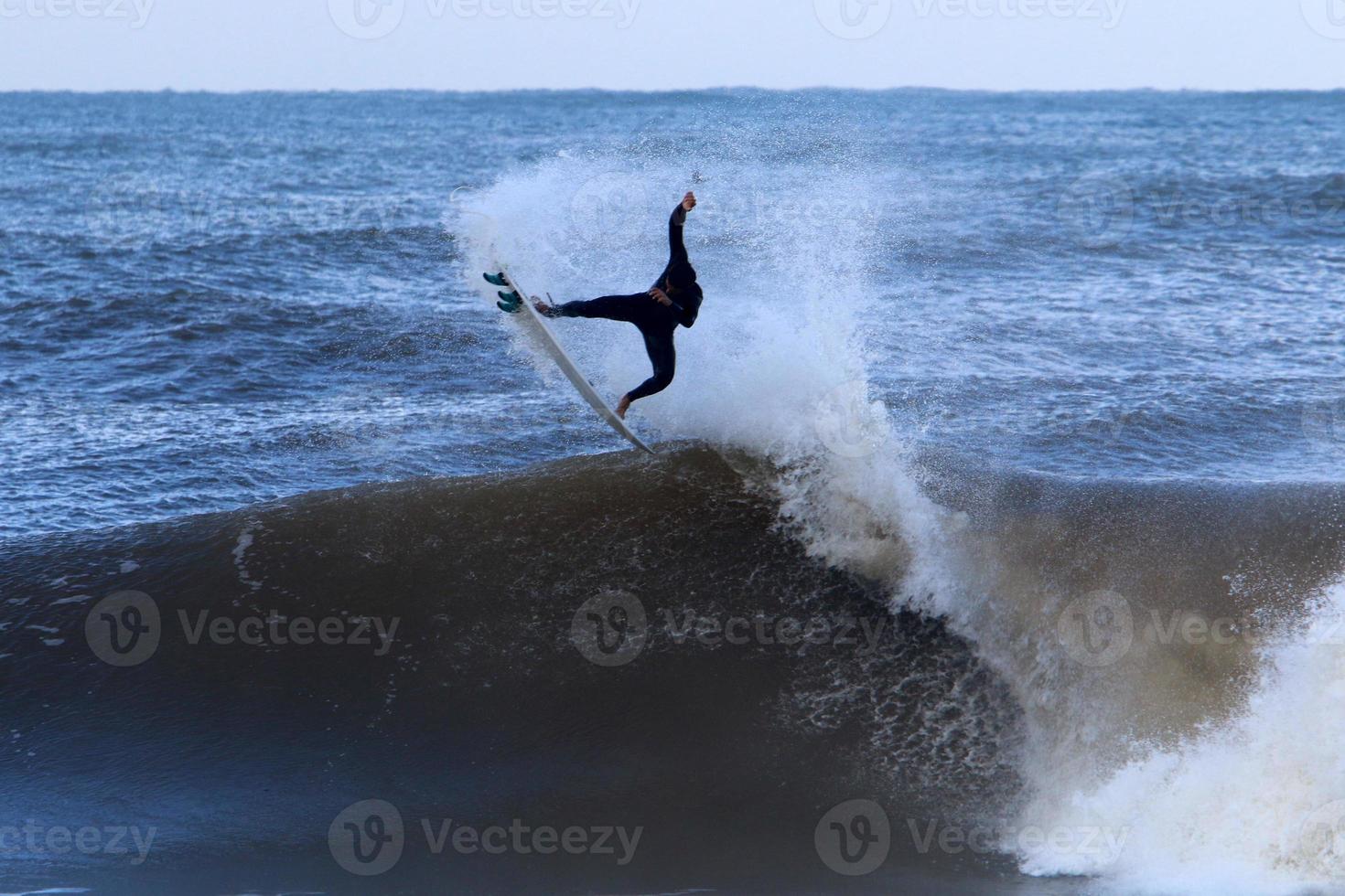 Surfing on high waves on the Mediterranean Sea in northern Israel. photo