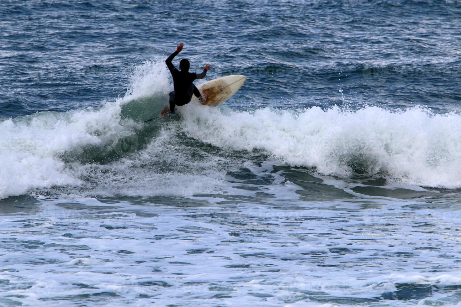 surfeando en olas altas en el mar mediterráneo en el norte de israel. foto