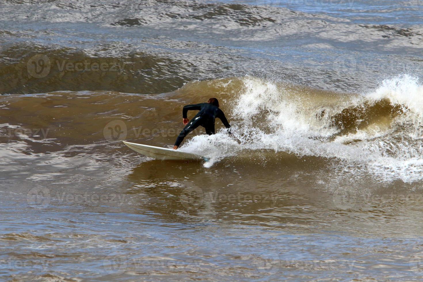 Surfing on high waves on the Mediterranean Sea in northern Israel. photo