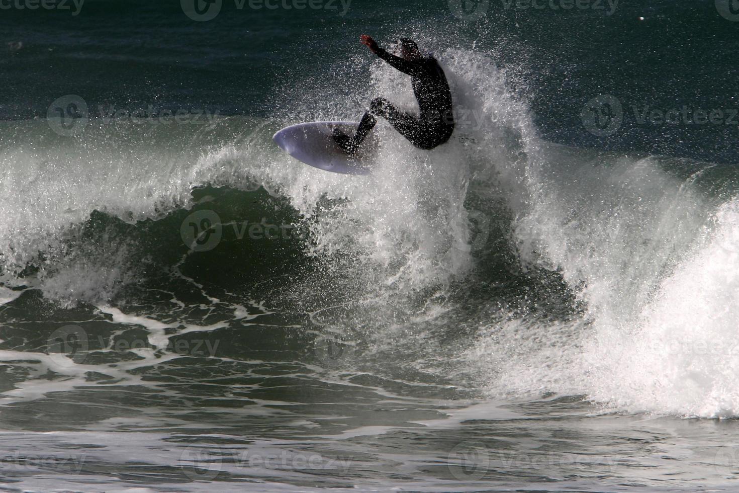 surfeando en olas altas en el mar mediterráneo en el norte de israel. foto