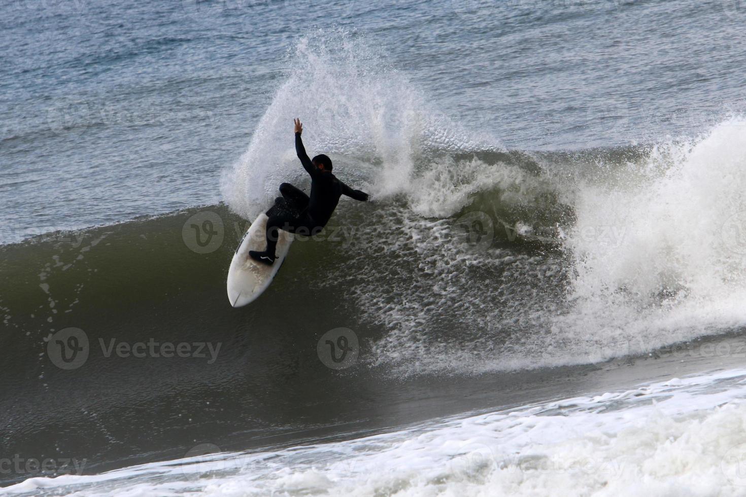 surfeando en olas altas en el mar mediterráneo en el norte de israel. foto