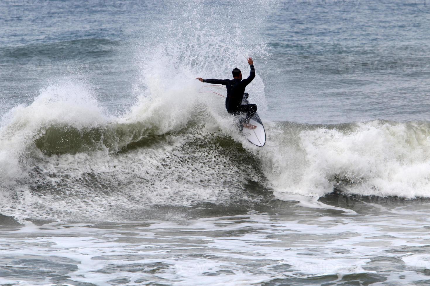 surfeando en olas altas en el mar mediterráneo en el norte de israel. foto