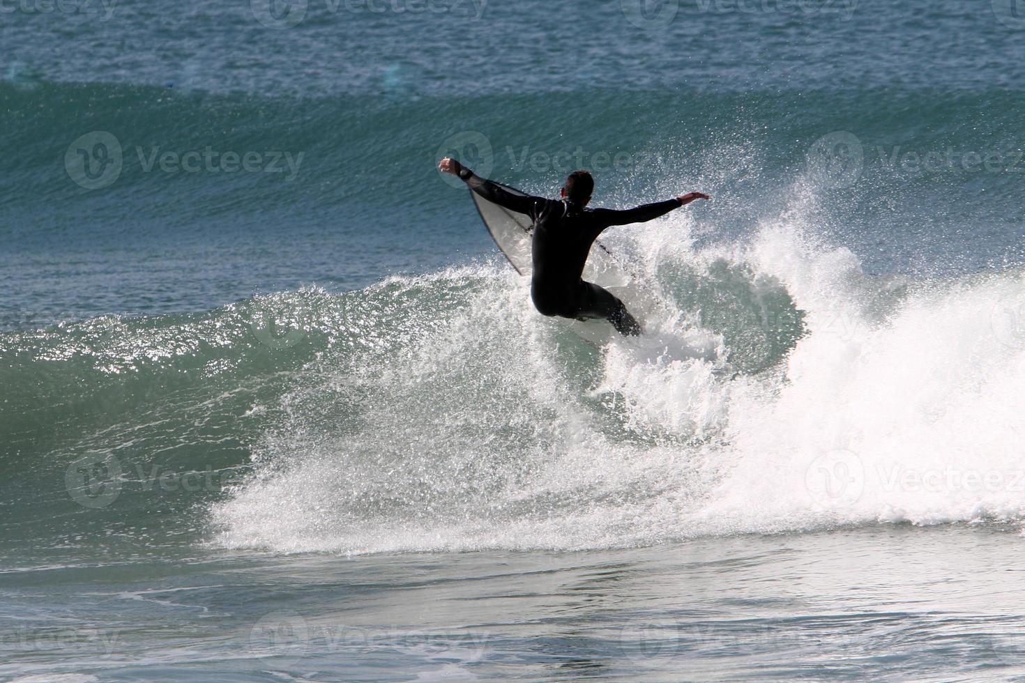 Surfing on high waves on the Mediterranean Sea in northern Israel. photo