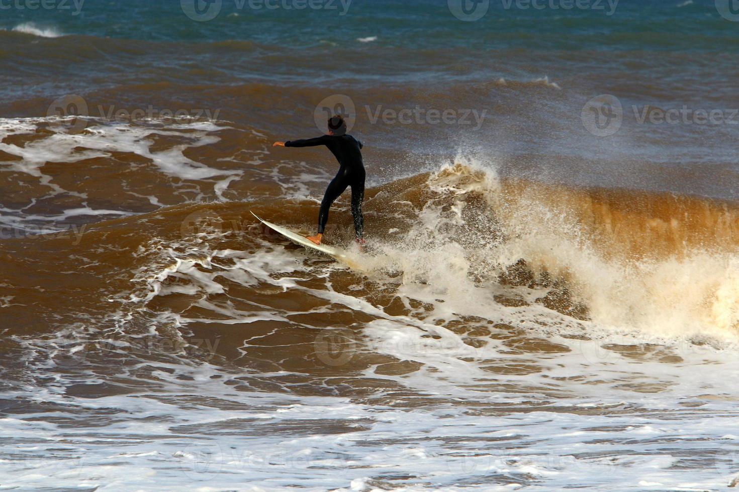 Surfing on high waves on the Mediterranean Sea in northern Israel. photo