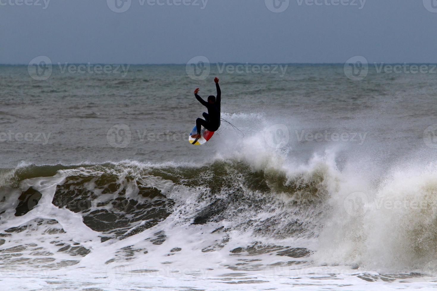 Surfing on high waves on the Mediterranean Sea in northern Israel. photo