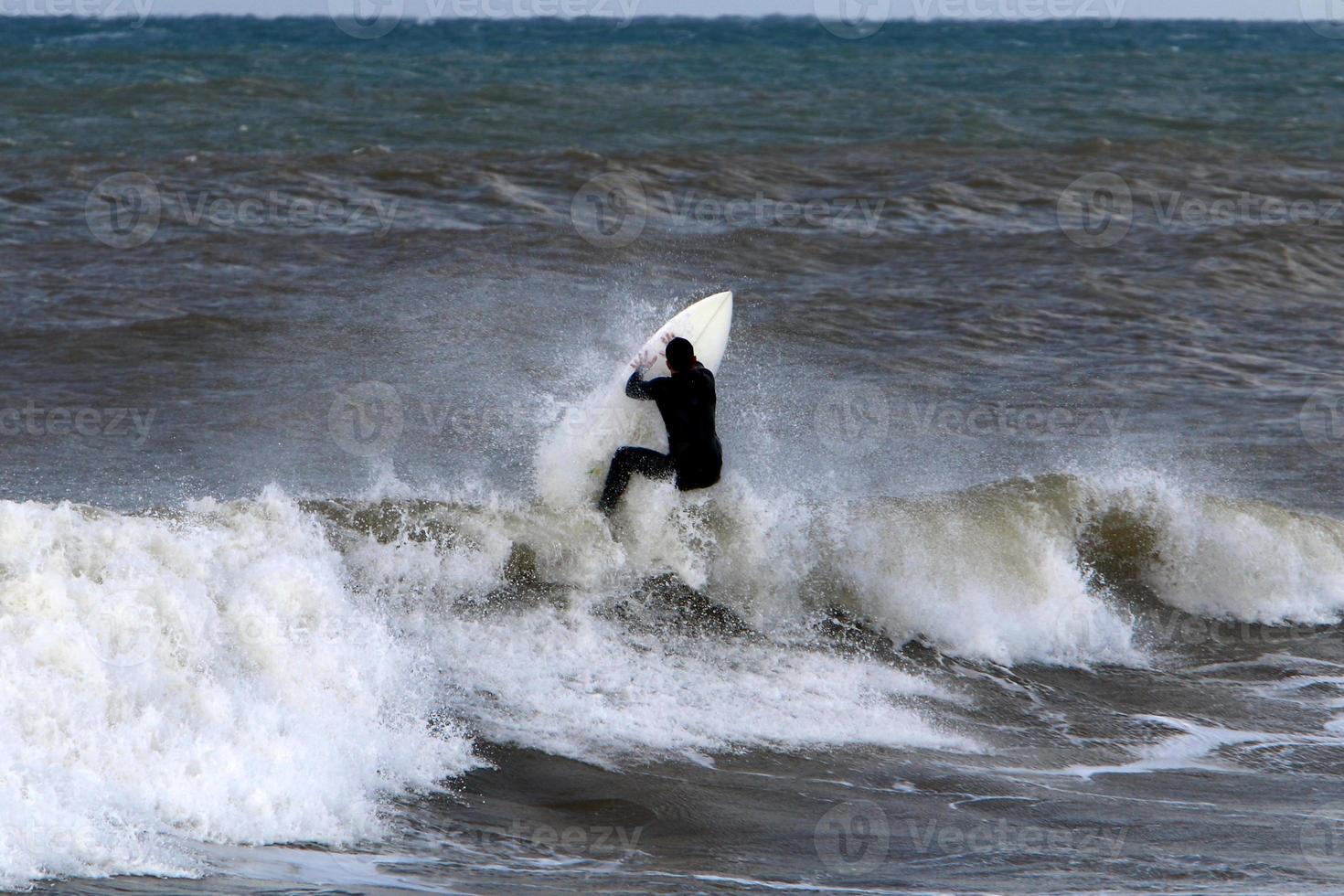 Surfing on high waves on the Mediterranean Sea in northern Israel. photo