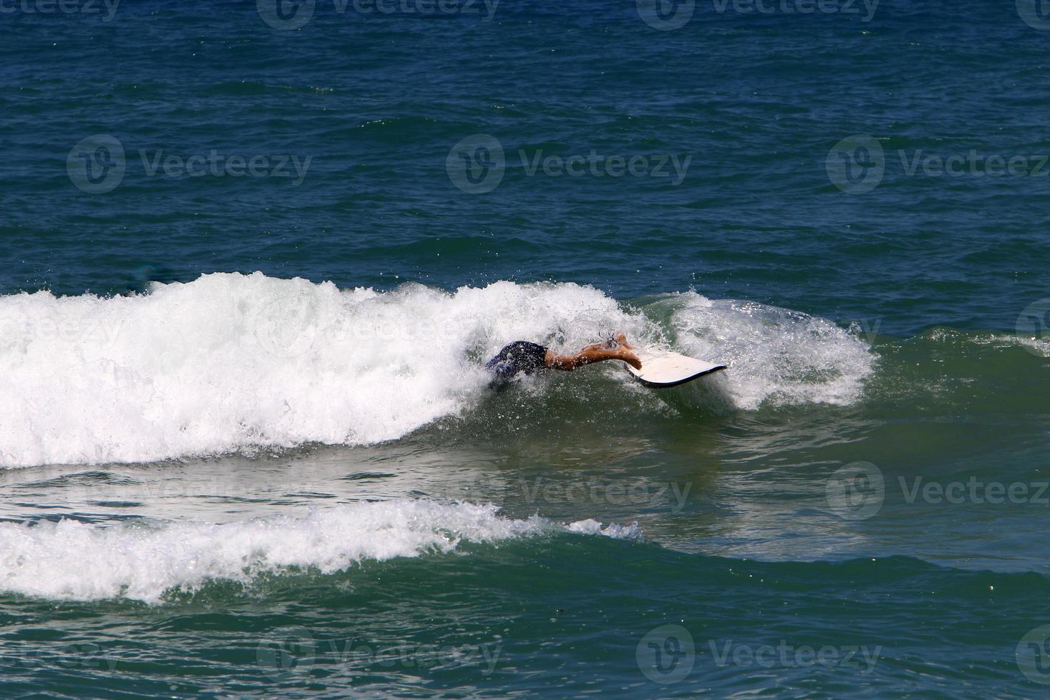 Surfing on high waves on the Mediterranean Sea in northern Israel. photo