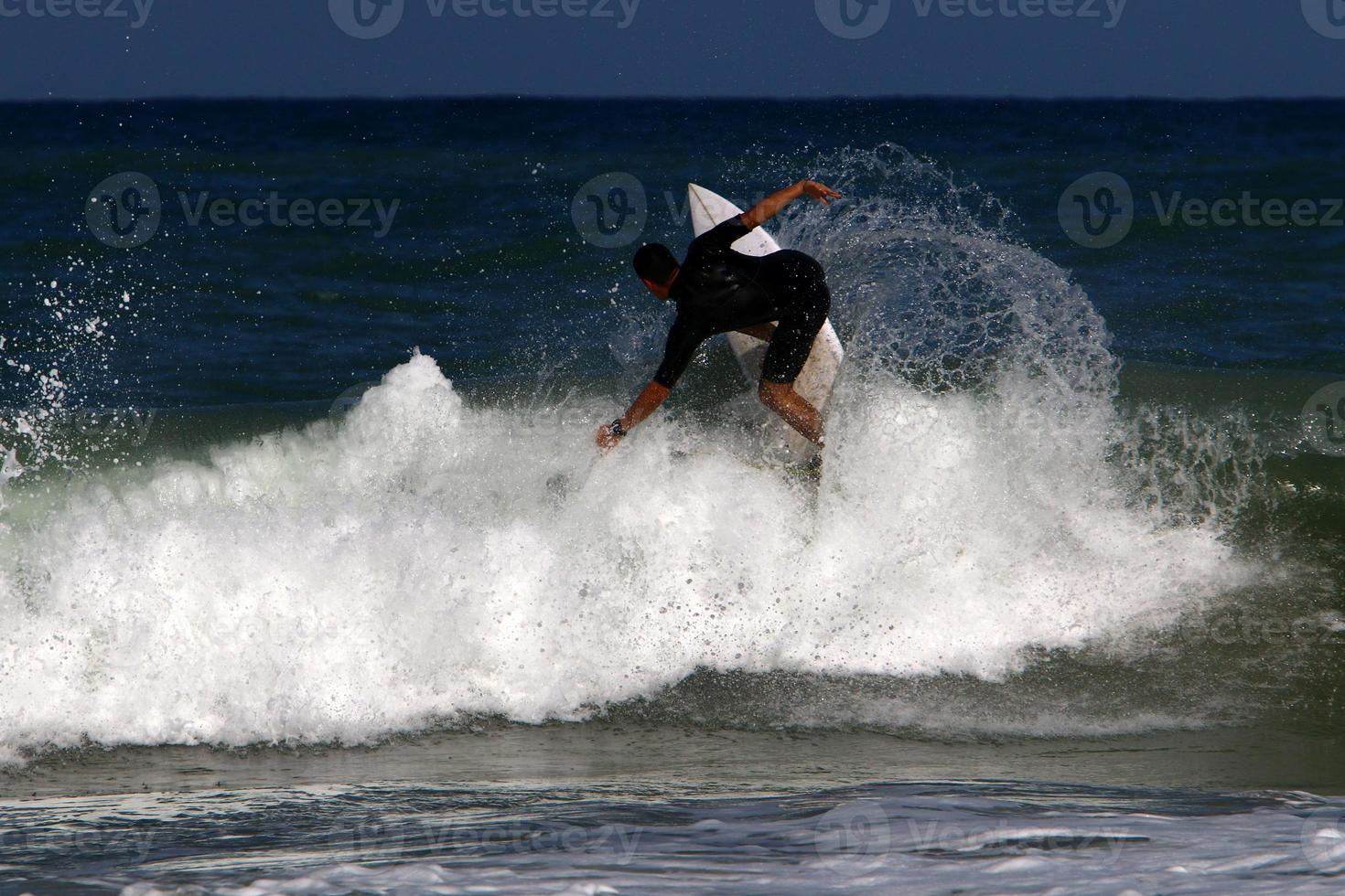 Surfing on high waves on the Mediterranean Sea in northern Israel. photo