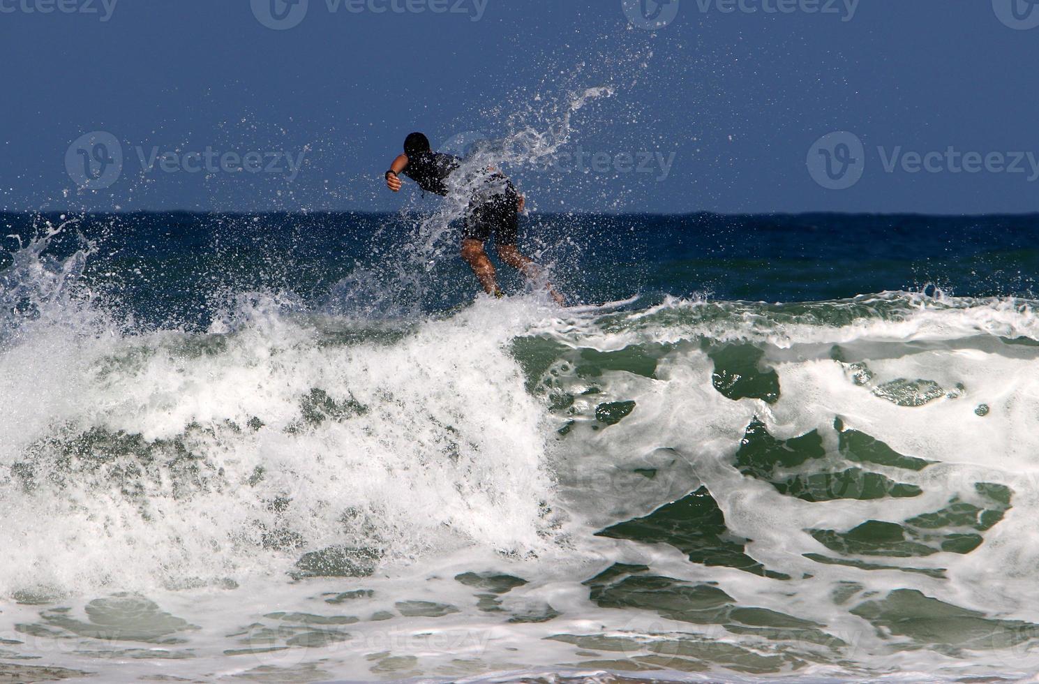 Surfing on high waves on the Mediterranean Sea in northern Israel. photo