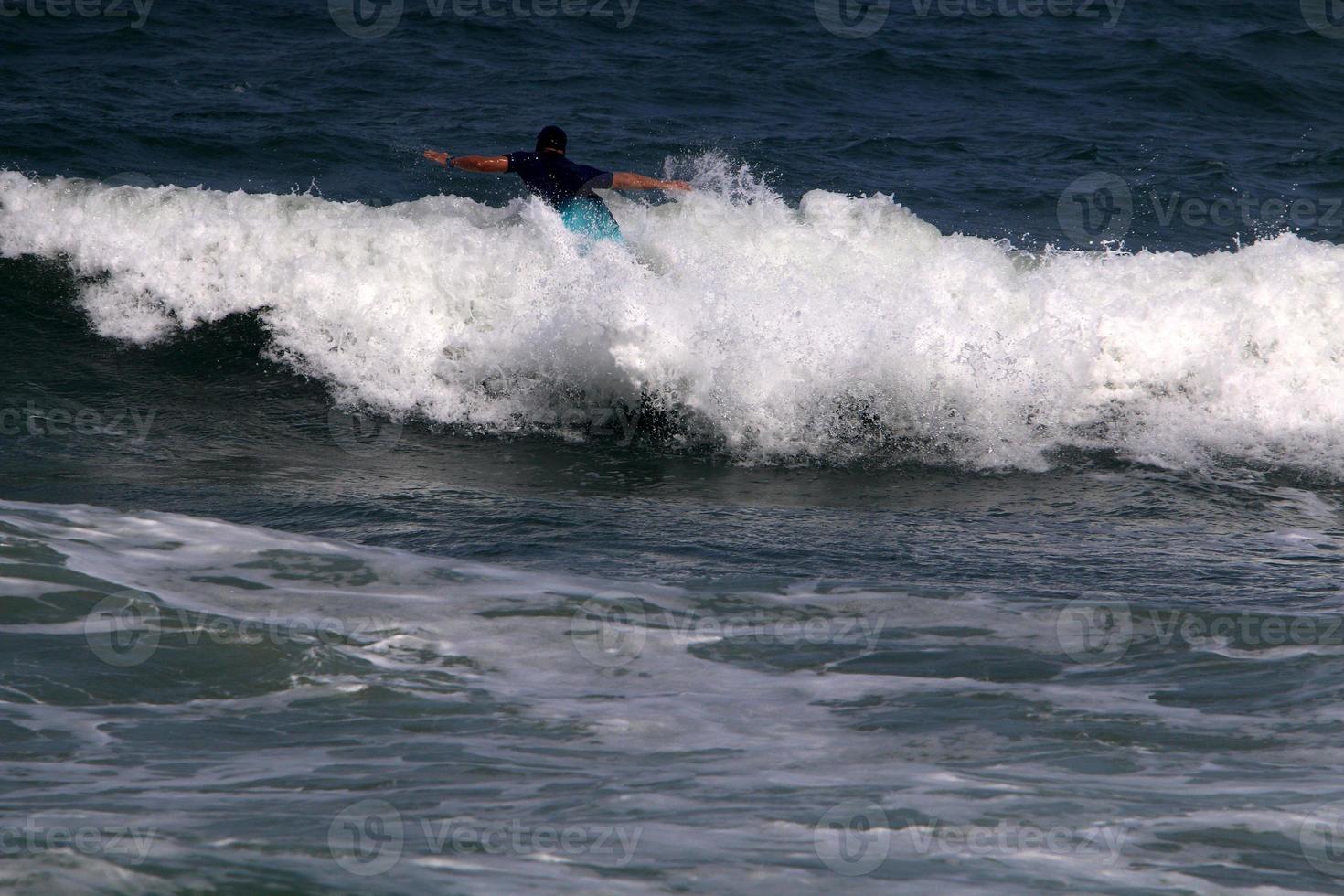 surfeando en olas altas en el mar mediterráneo en el norte de israel. foto