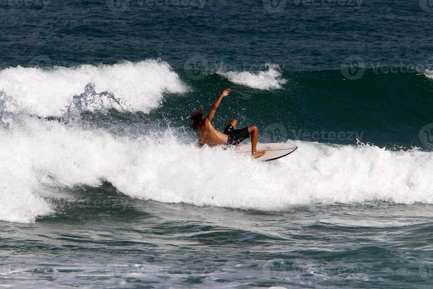 Surfing on high waves on the Mediterranean Sea in northern Israel. photo