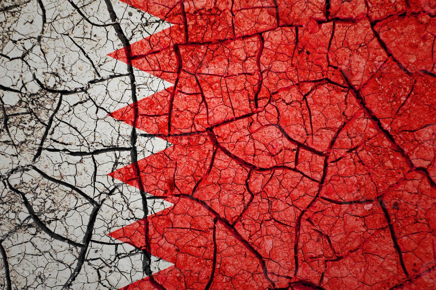 Dry soil pattern on the flag of Bahrain. Country with drought concept. Water problem. Dry cracked earth country. photo