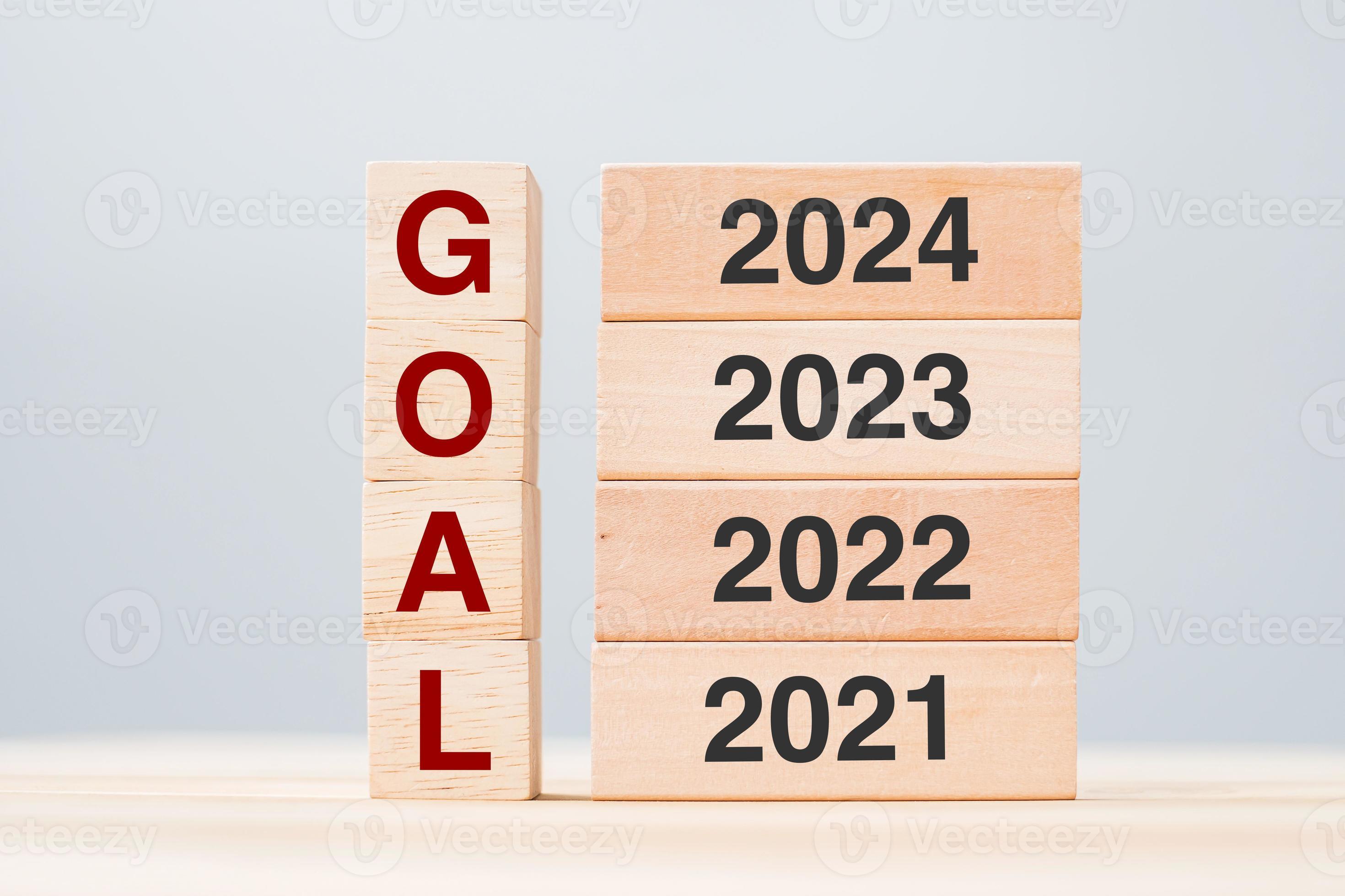 2025 block over 2023 and 2022 wooden building on table background