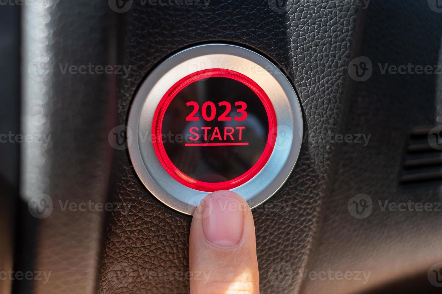 Finger press a car ignition button with 2023 START text inside  automobile. New Year New You, forecast, resolution, motivation, change, goal, vision, innovation and planning concept photo