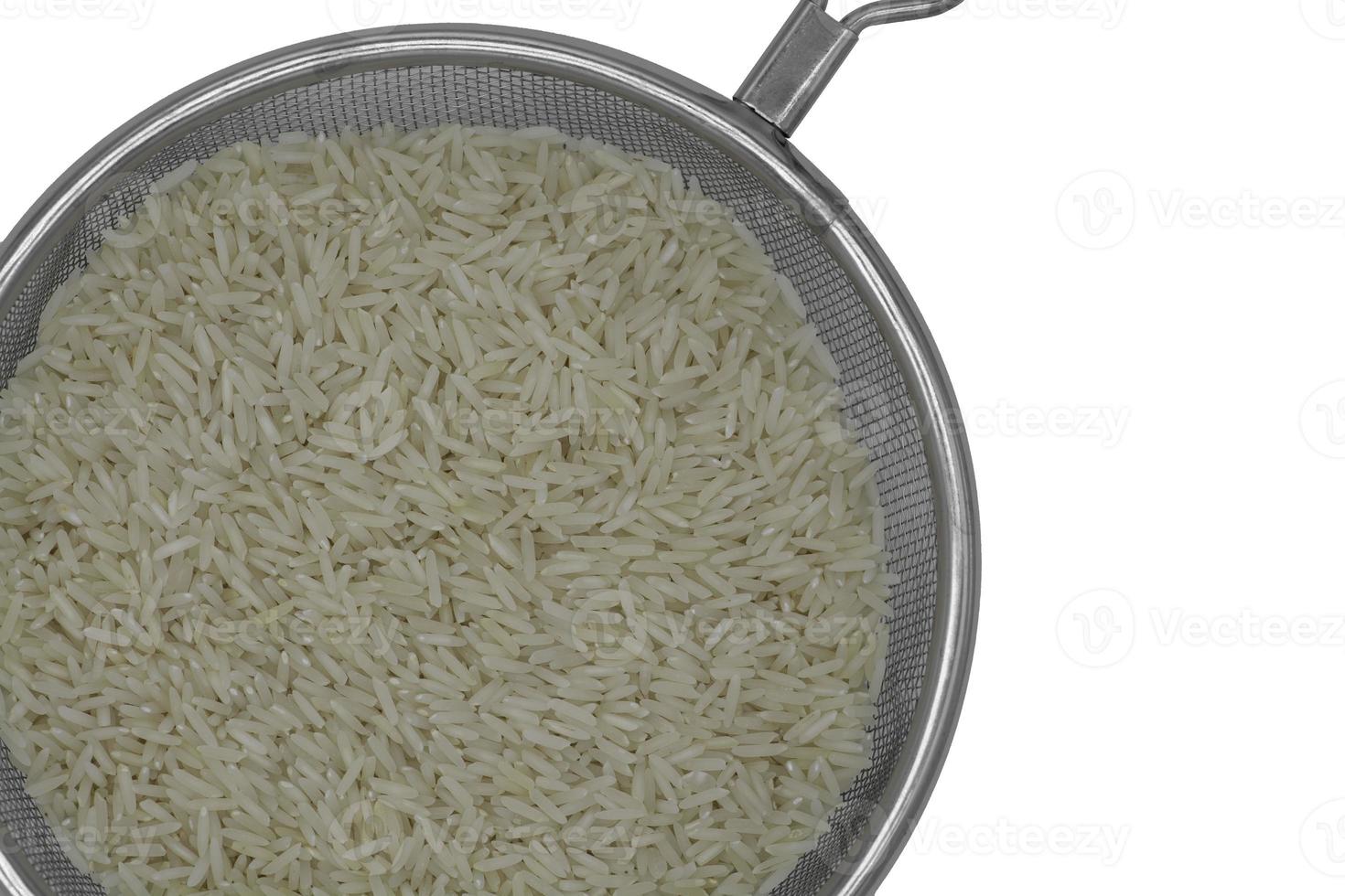 Raw white rice in a colander strainer isolated on white background photo
