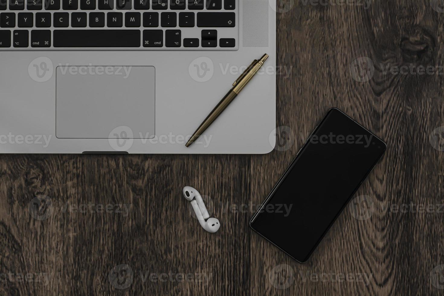 work from home with a smartphone, headphones and laptop setup photo