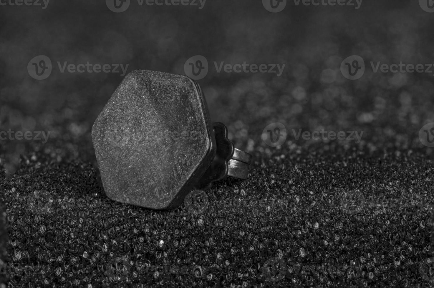 close-up of matt hexagon earring on glittery silver background photo