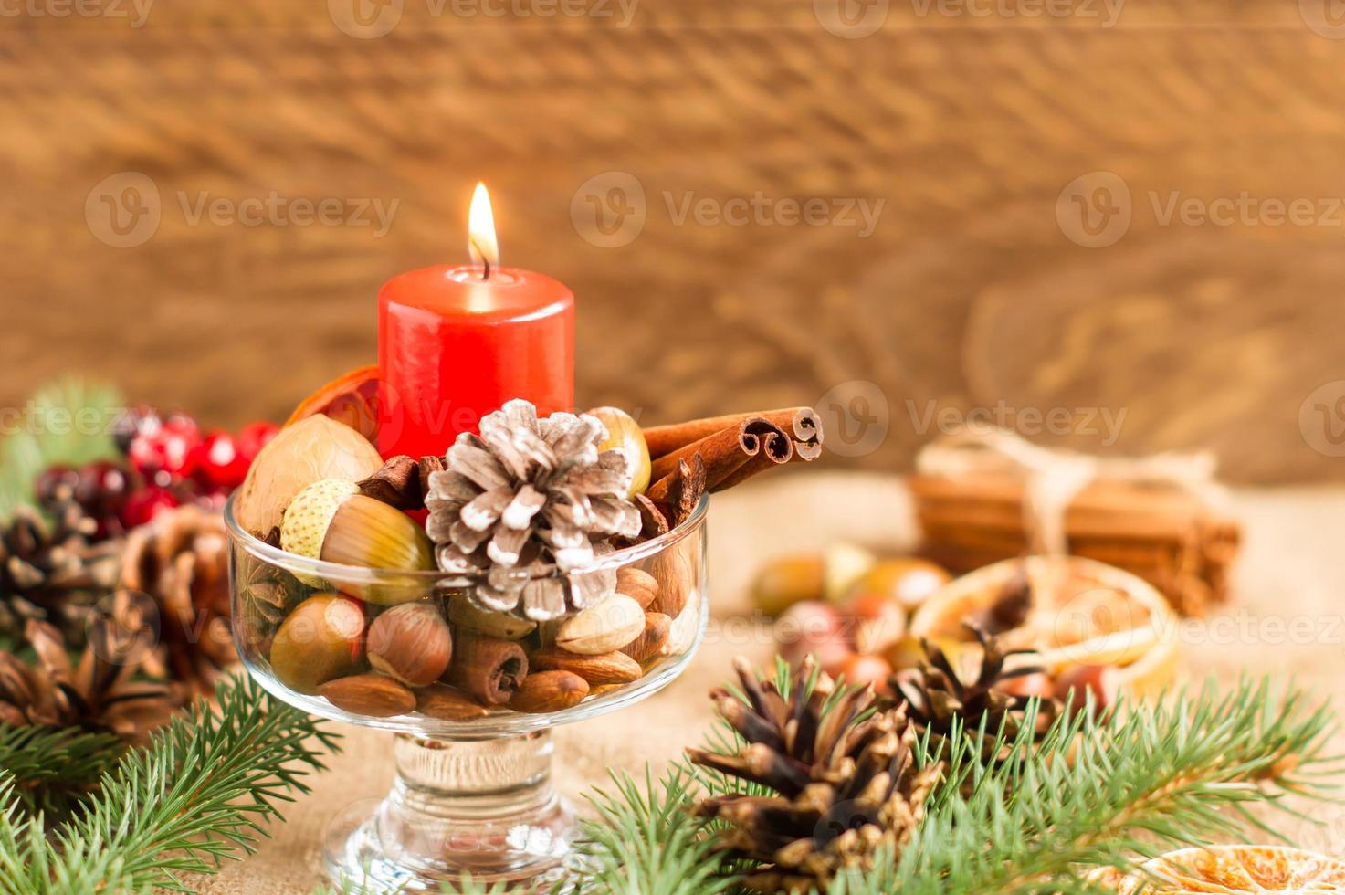 composición de año nuevo para decorar la casa y la mesa en las fiestas de nacimiento. materiales naturales, conos, ramas, nueces, velas encendidas. foto