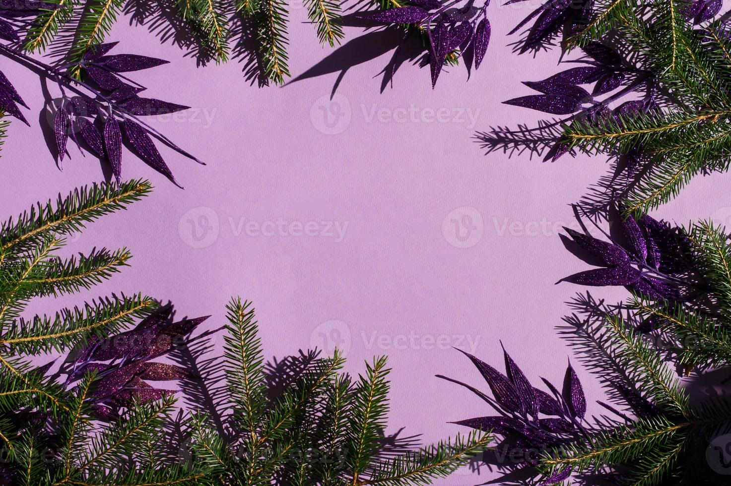 fondo festivo o de año nuevo con elementos decorativos de ramas de abeto y hojas decorativas lilas con lentejuelas. una copia del espacio. foto