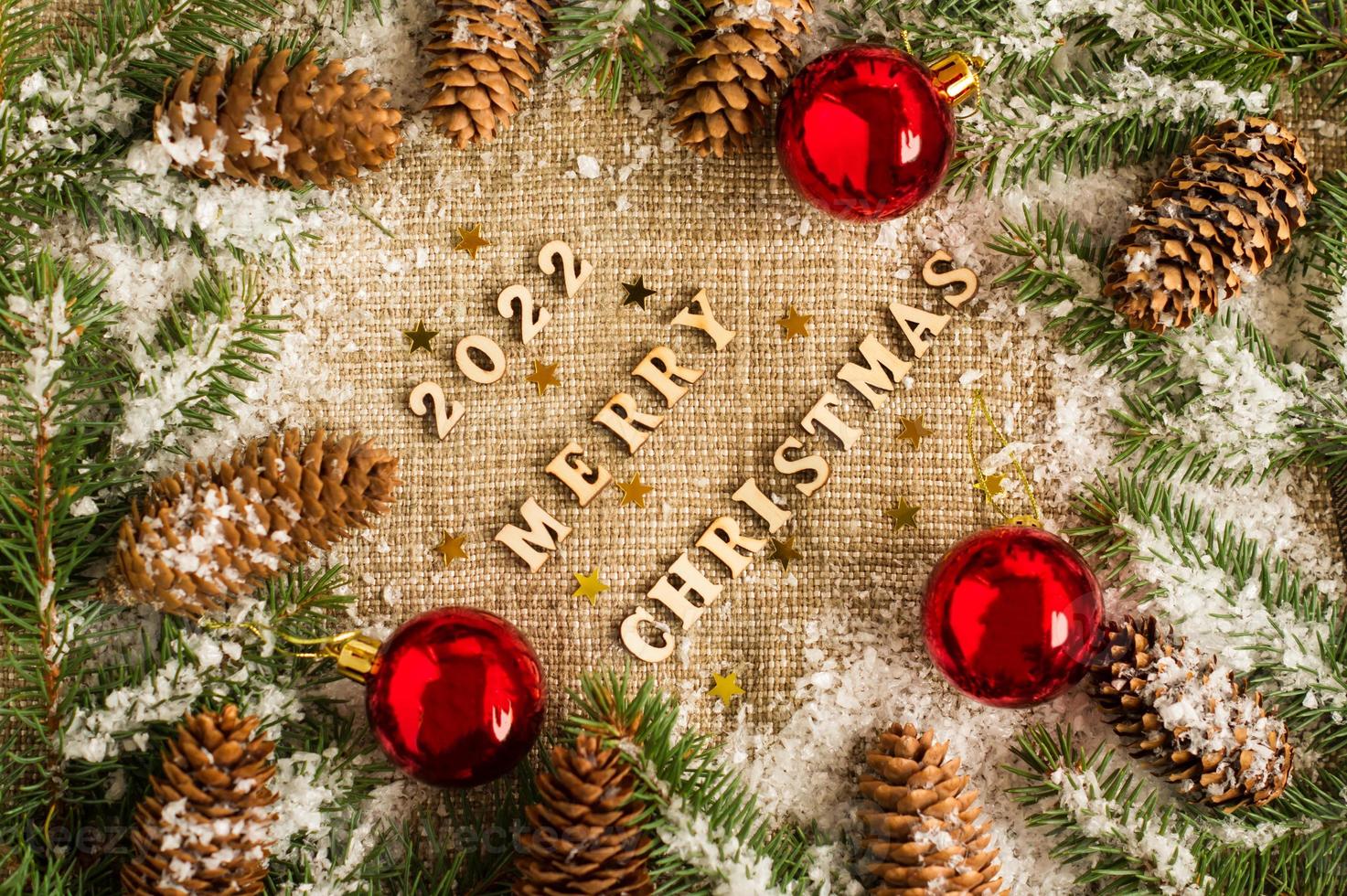 Christmas and New Year's background on burlap with the numbers of the coming year, spruce branches, cones and toys, red balls. top view. photo