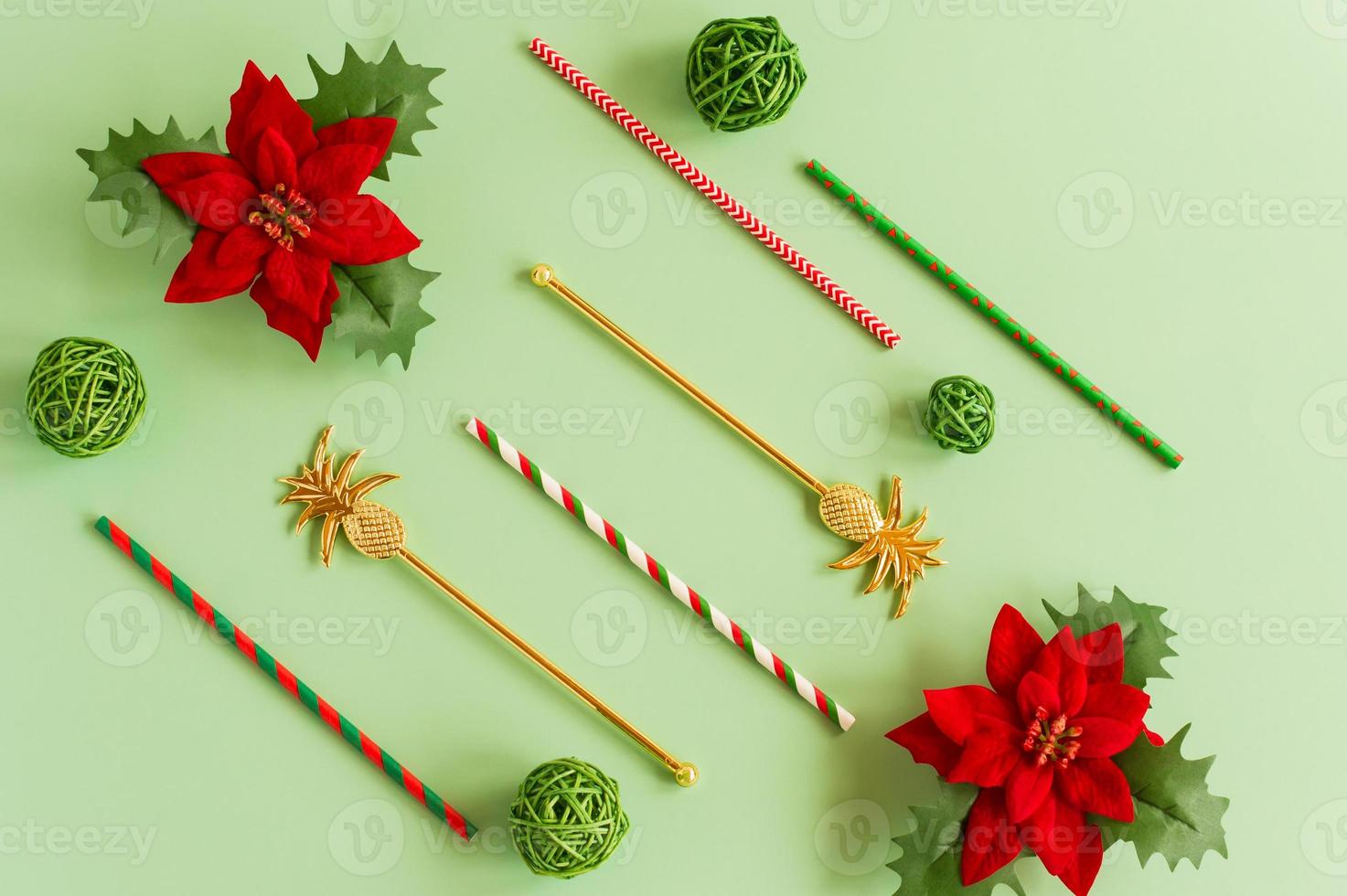 flat layout of New Year's bright cocktail tubes with red flowers- a symbol of the new year and Christmas on a green background. photo