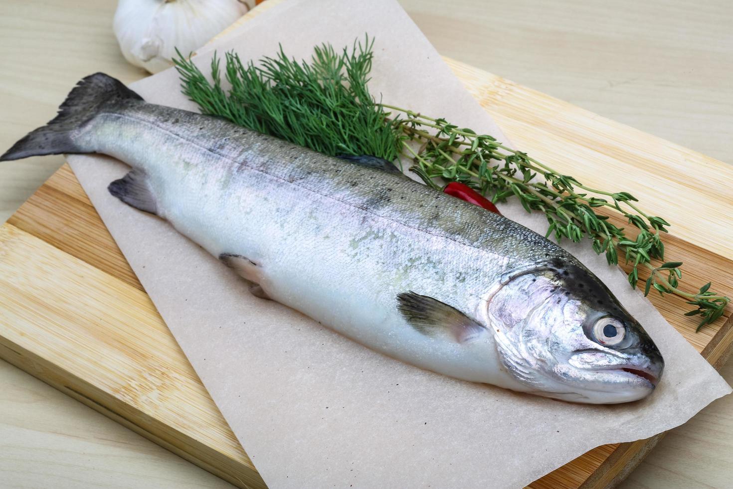 Raw trout on wooden board and wooden background photo