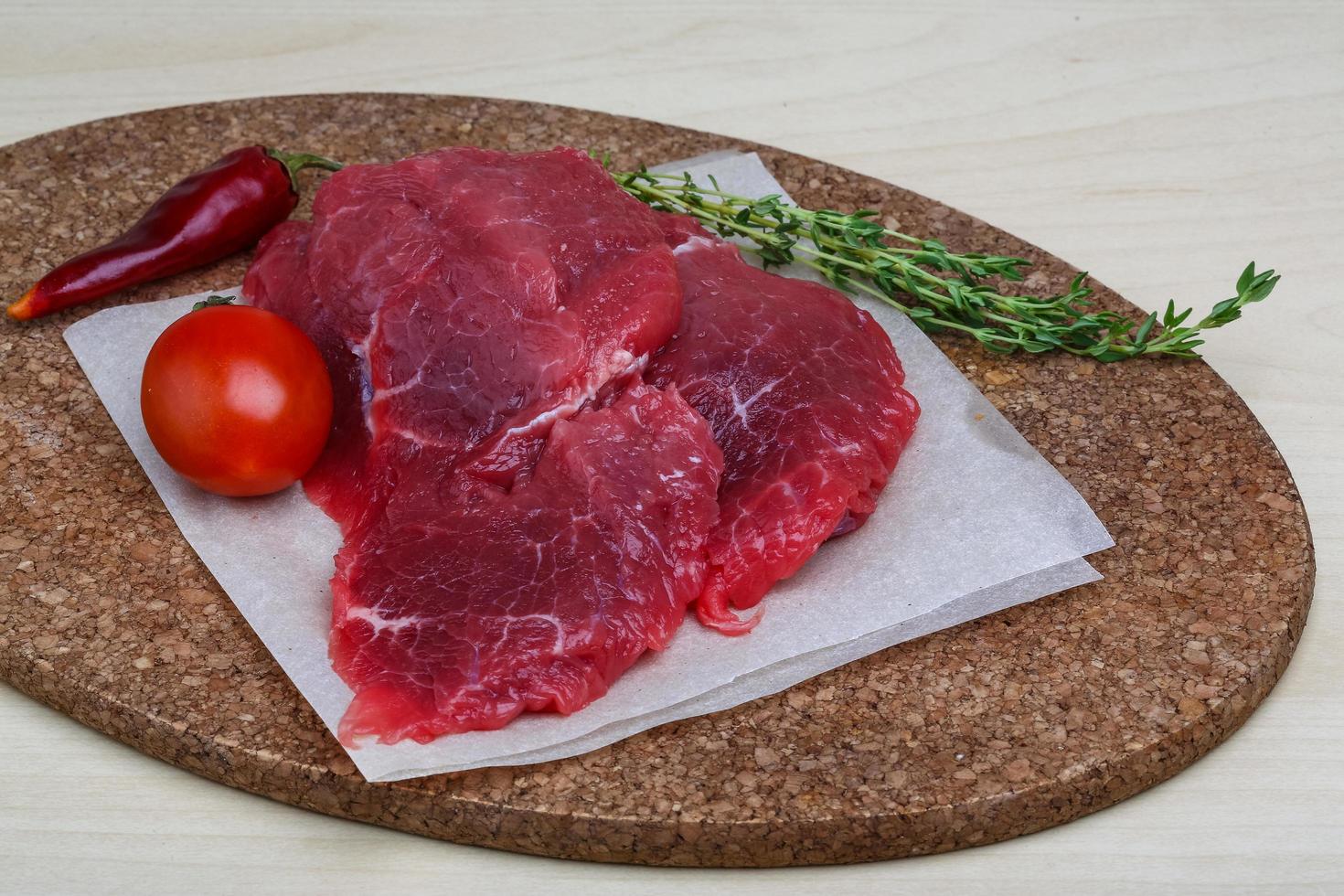 Raw beef on wooden board and wooden background photo