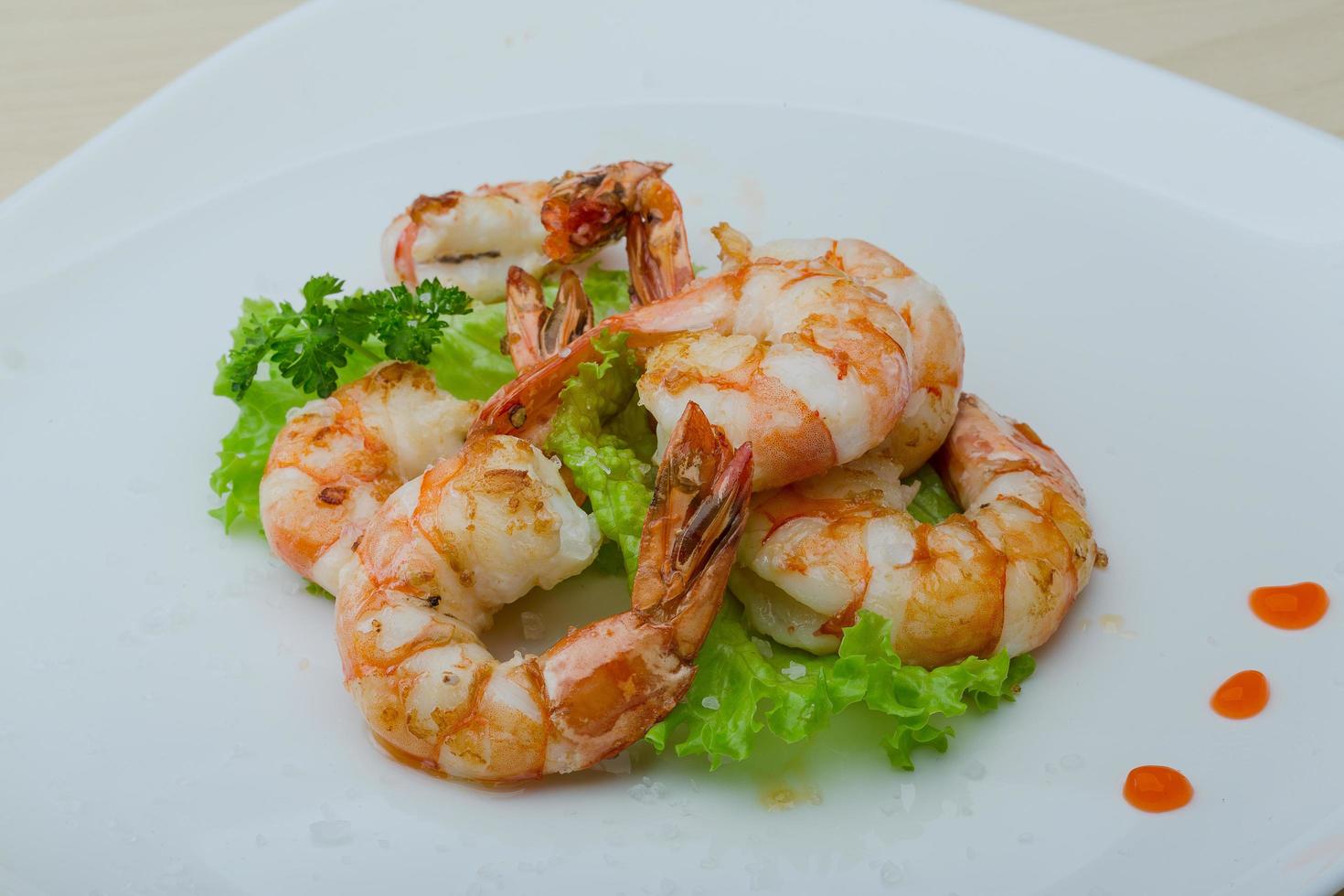 Tiger shrimps on the plate and wooden background photo