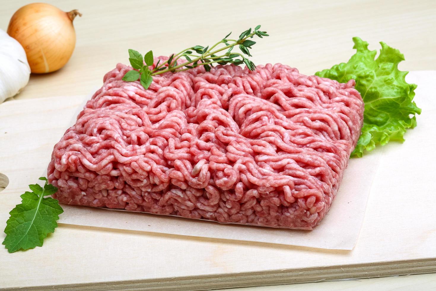 Minced meat on wooden board and wooden background photo