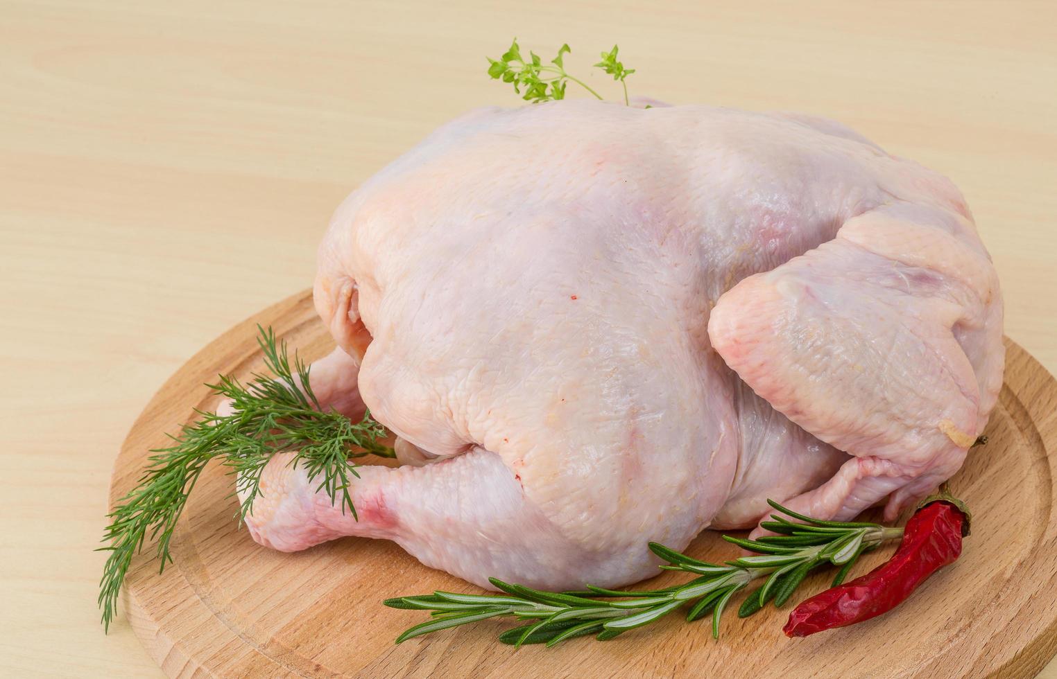 Raw chicken on wooden board and wooden background photo