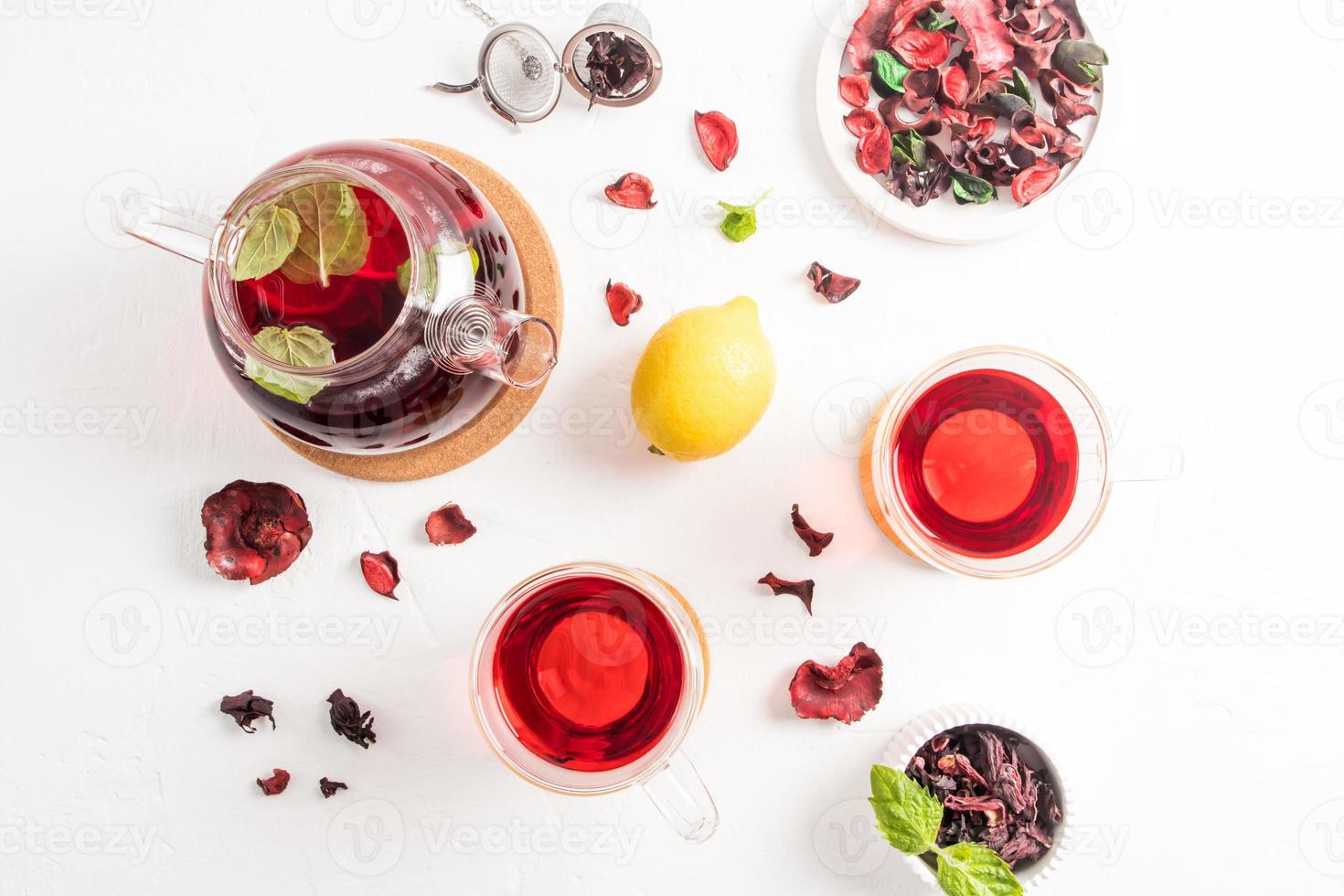 delicious aromatic tea from rose petal hibiscus in a teapot with mint leaves and lemon. healing tea for flu and colds. top view. flat styling. photo