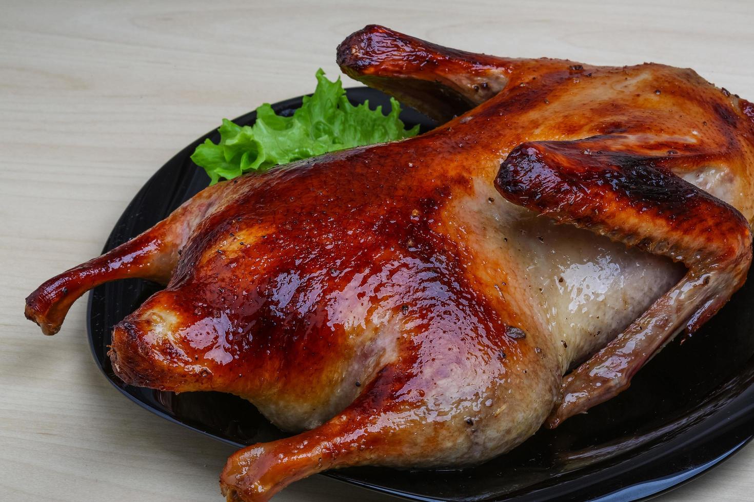 pato asado en el plato y fondo de madera foto