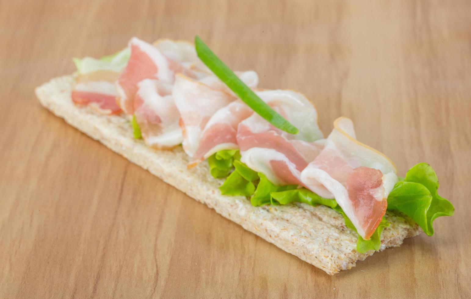 Bacon sandwich on wooden background photo