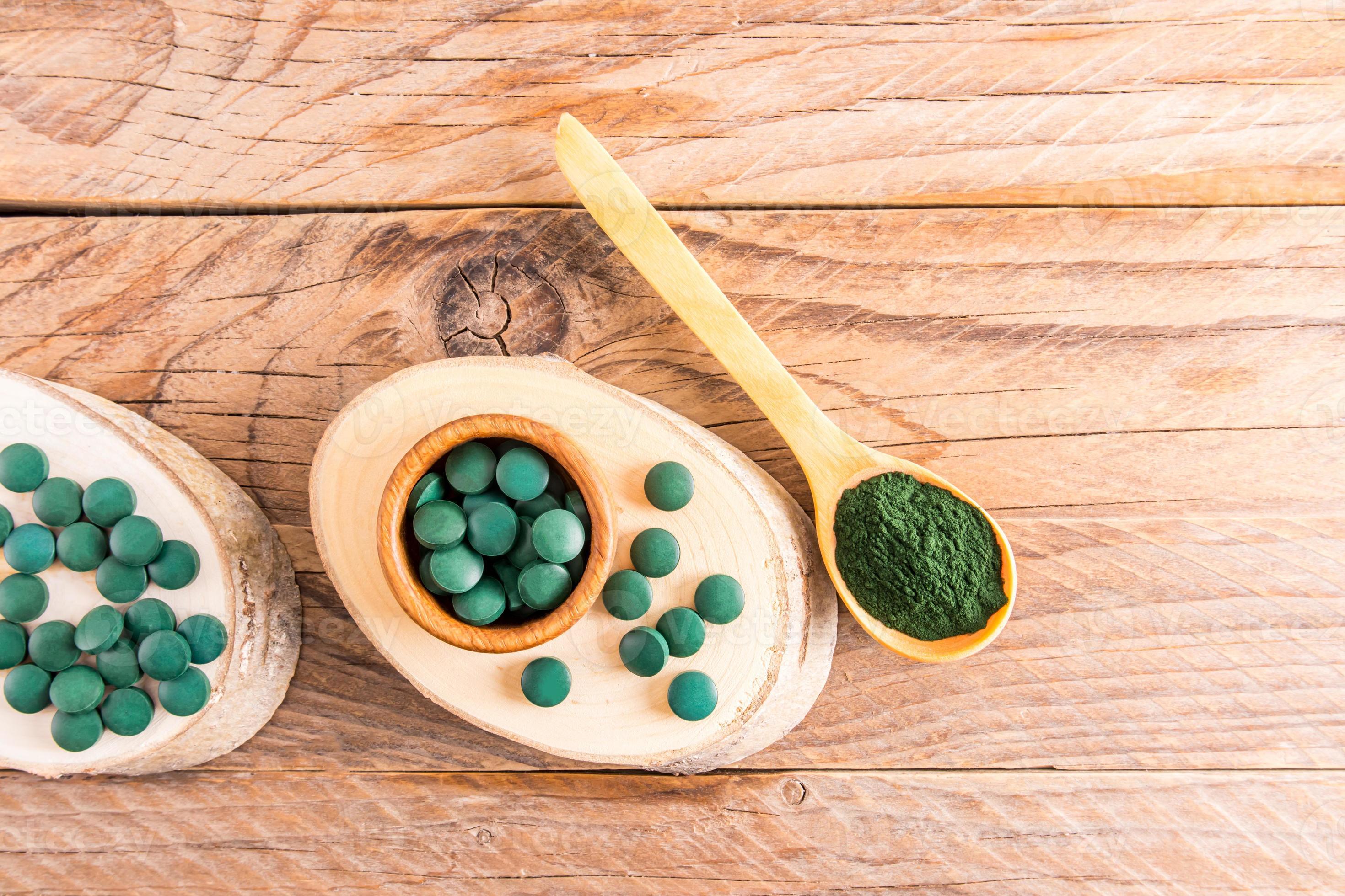 suelo de espirulina y tabletas de espirulina sobre el fondo de tablas