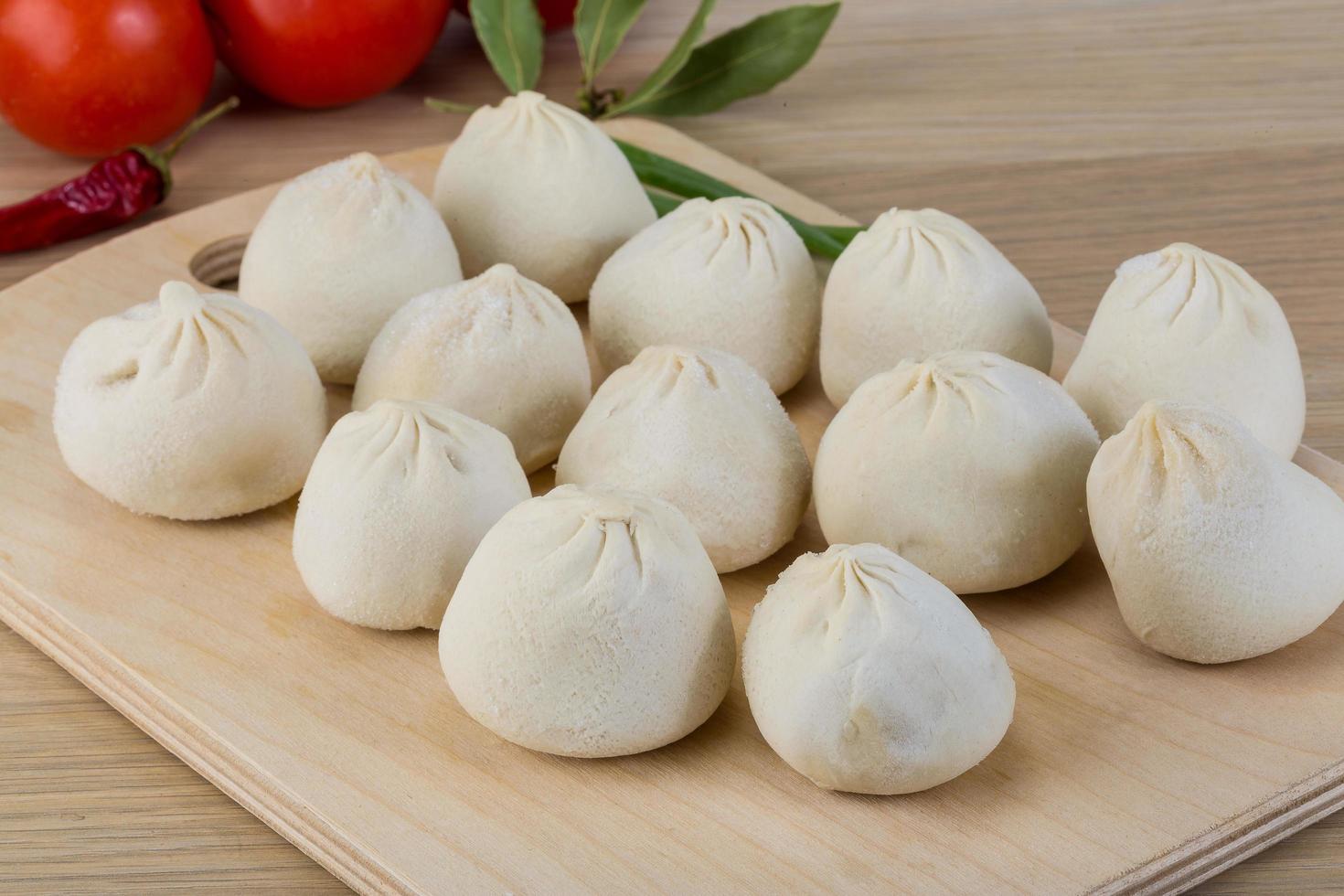 Khinkali on wooden board and wooden background photo