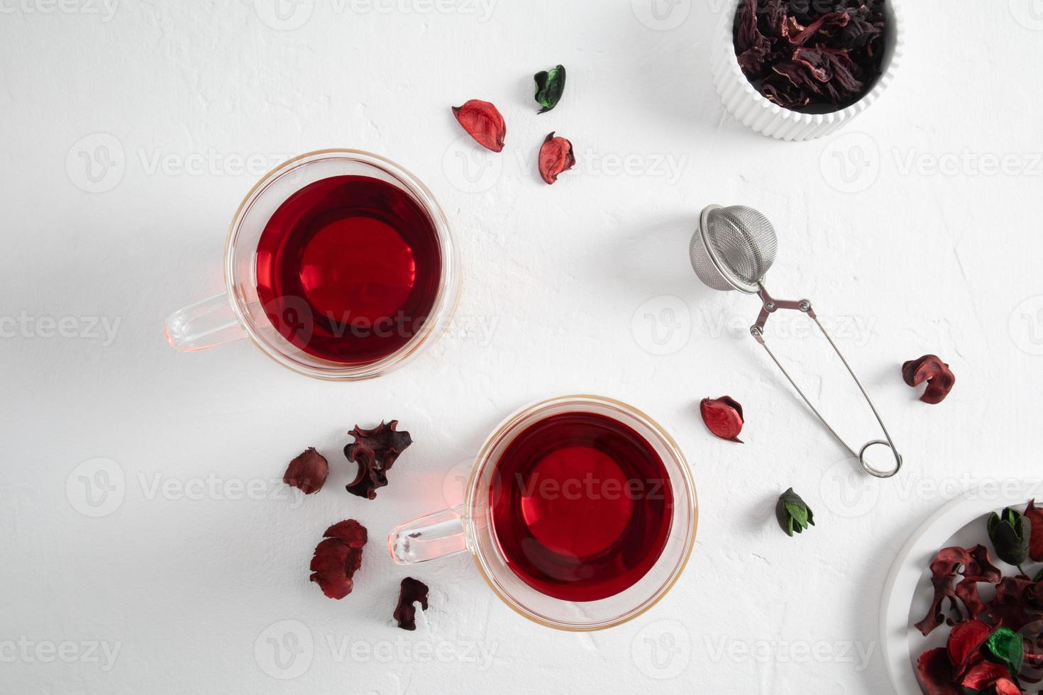 two modern glass cups of hibiscus or hibiscus tea on a white background with dried flowers. organic tea rich in vitamins and amino acids. photo