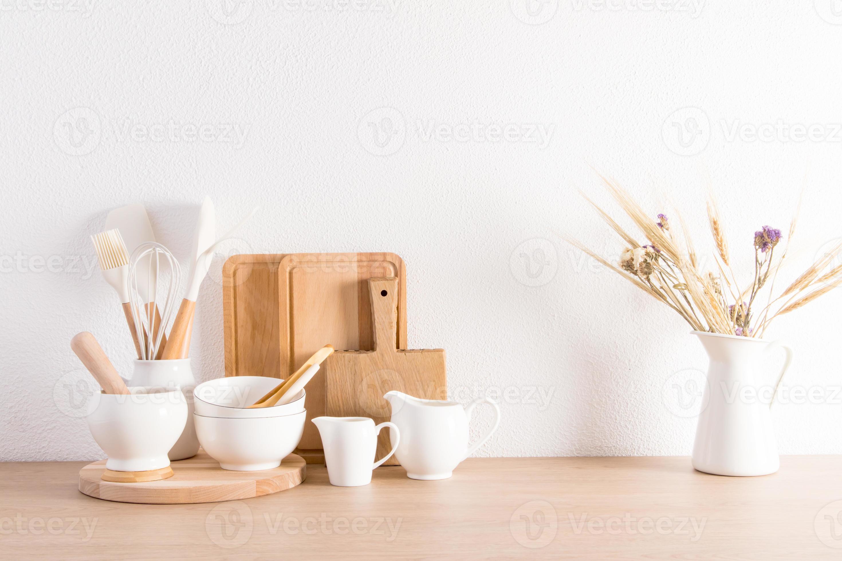 Stylish white kitchen background with utensils and dried flower in a