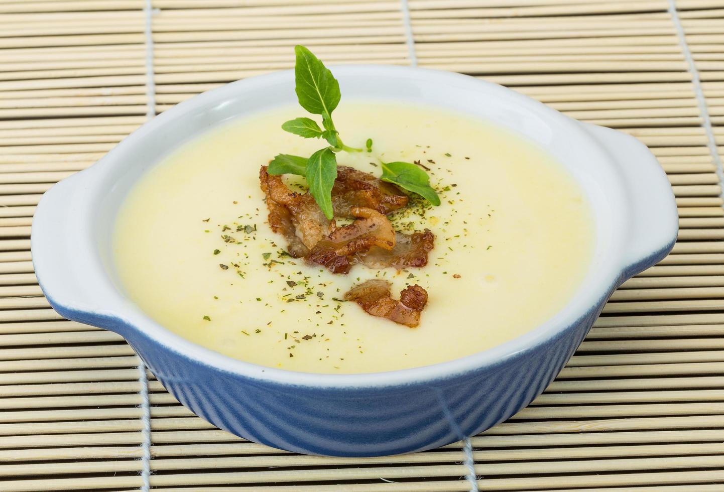 sopa de queso en un bol sobre fondo de madera foto