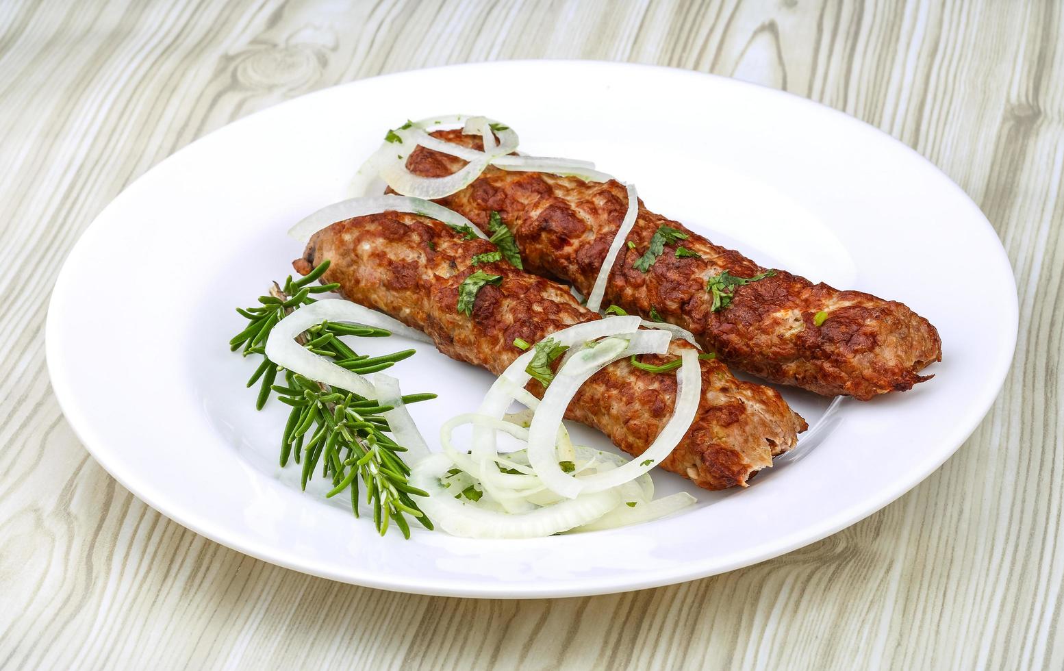 Beef kebab on the plate and wooden background photo