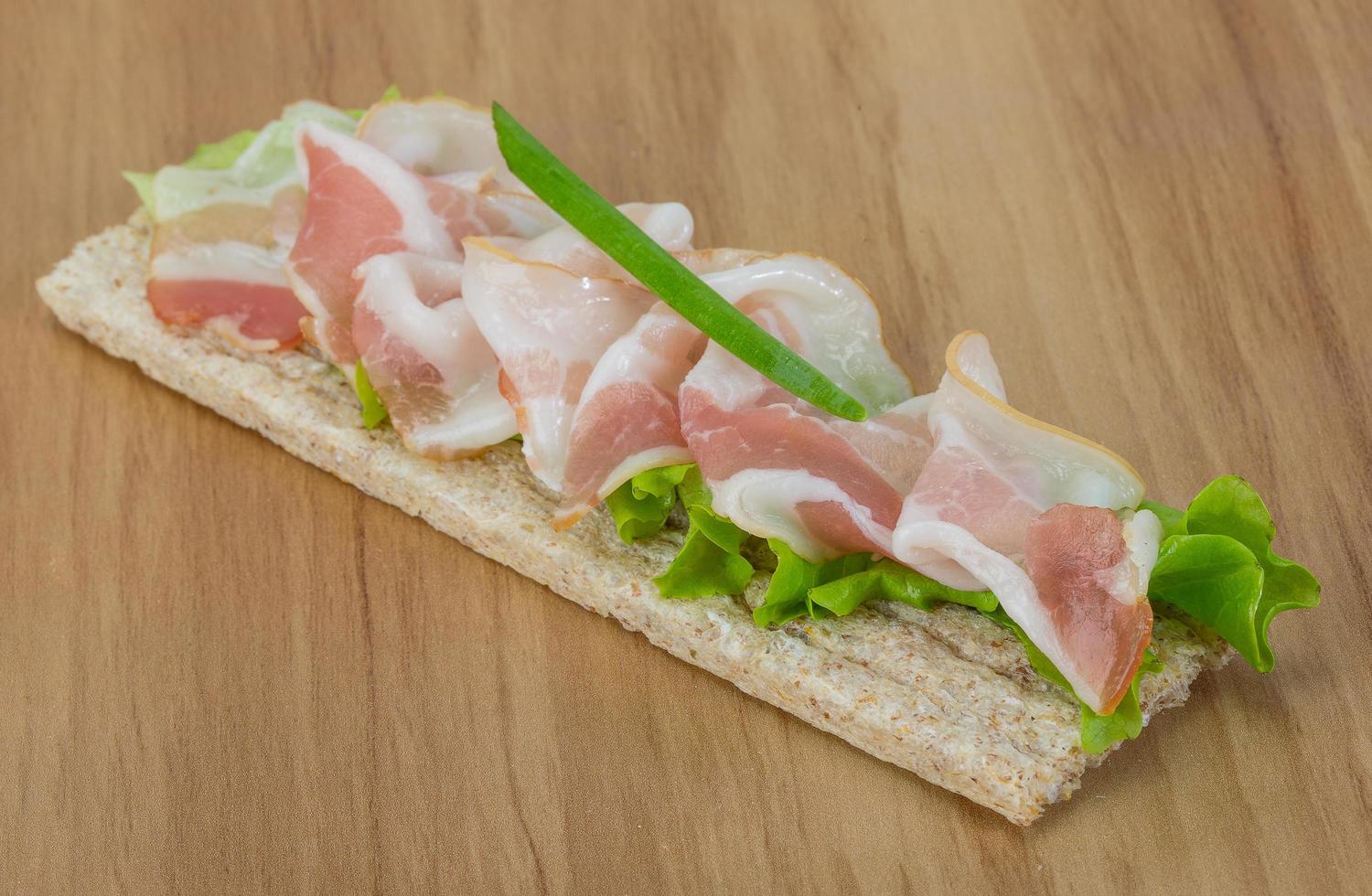 Bacon sandwich on wooden background photo